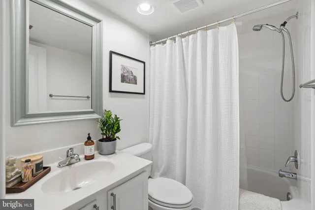 a bathroom with a sink vanity mirror and toilet