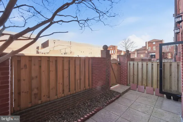 a view of a pathway of a building with wooden fence