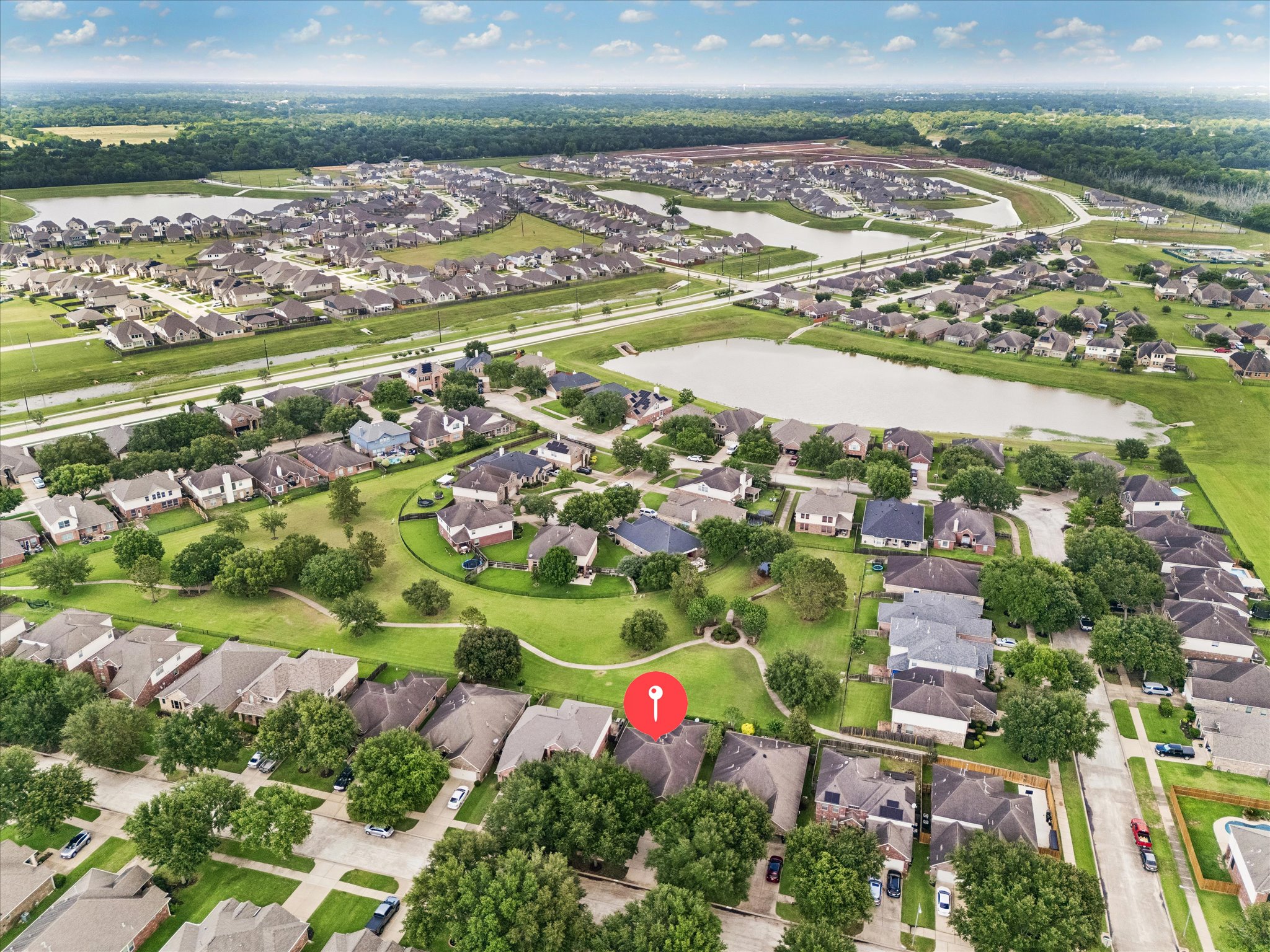 2214 Wembley Way Rosenberg, TX 77471 - Photo 4 of 35 Aerial view of a residential community featuring multiple homes, green spaces, and water features