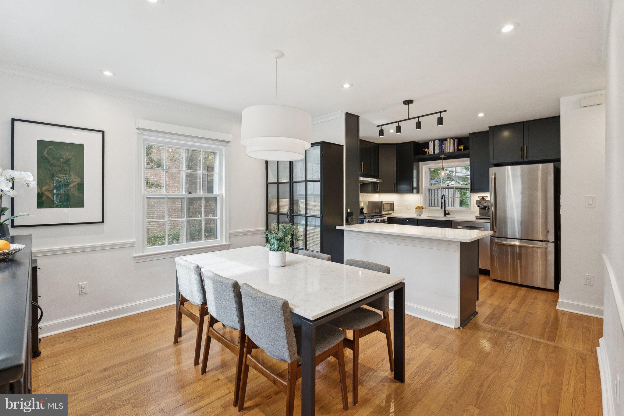3231 Beech Street Northwest Washington, DC 20015 - Photo 9 of 29 a kitchen with stainless steel appliances a dining table chairs refrigerator and cabinets