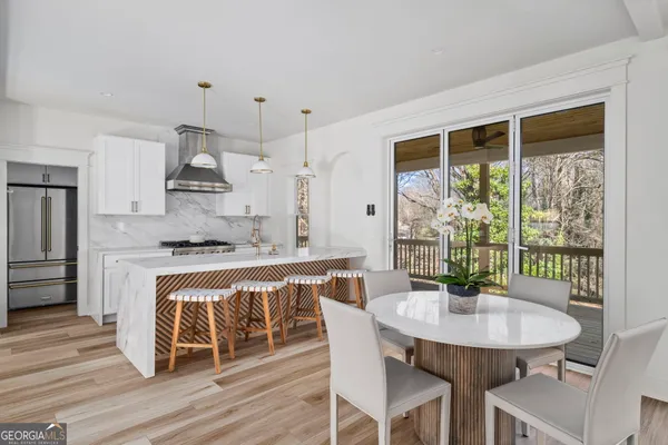 a kitchen with stainless steel appliances granite countertop a dining table chairs and granite counter tops