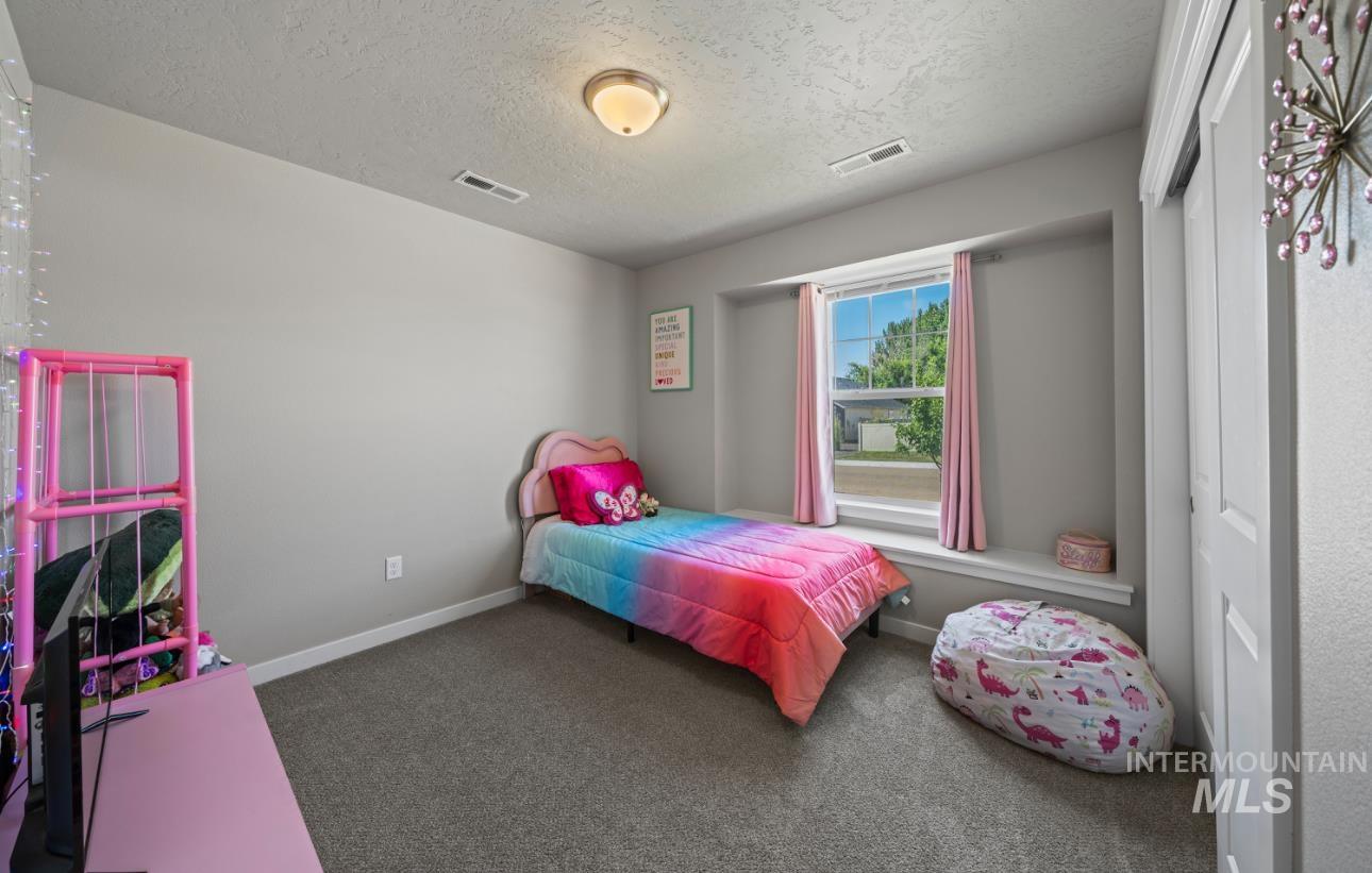 12443 Varga Street Caldwell, ID 83607 - Photo 25 of 27 Carpeted bedroom with a textured ceiling and baseboards