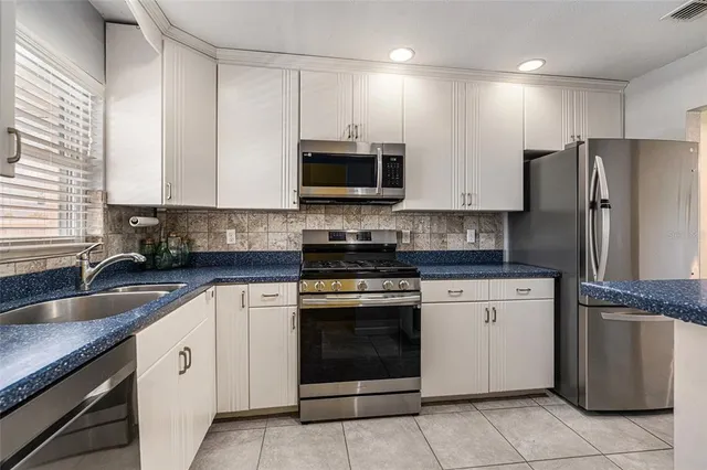 a kitchen with granite countertop a sink stove and refrigerator