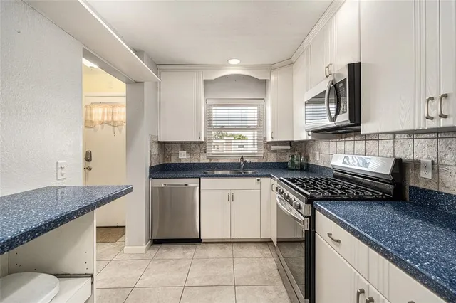 a kitchen with stainless steel appliances granite countertop a sink stove and cabinets