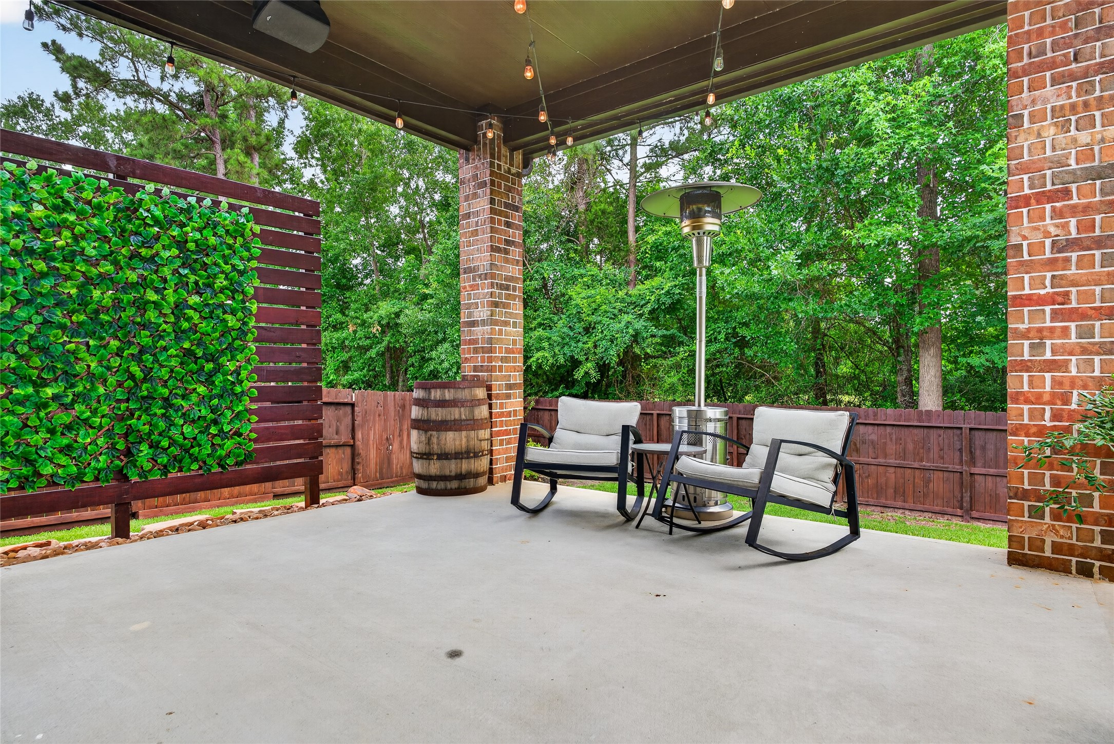 7907 Augusta Creek Court Spring, TX 77389 - Photo 41 of 49 This inviting outdoor covered patio features a cozy seating area perfect for relaxation. The space is surrounded by greenery, lush trees, and nature.... surely offering a tranquil and private atmosphere.