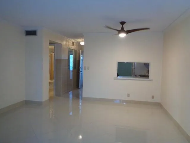 an empty room with an entryway and fan