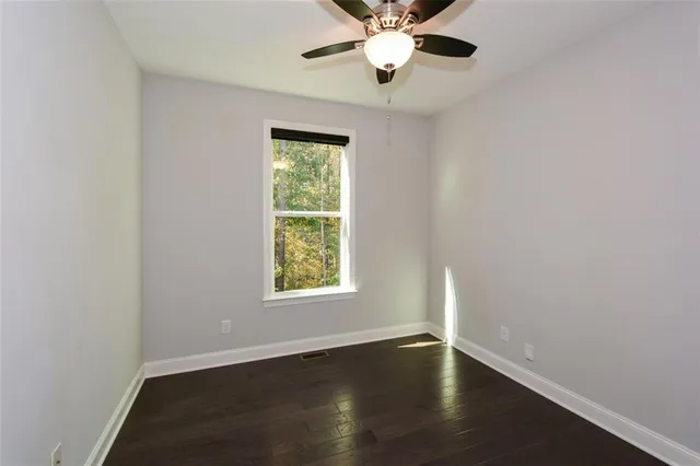 an empty room with a fireplace and wooden floor