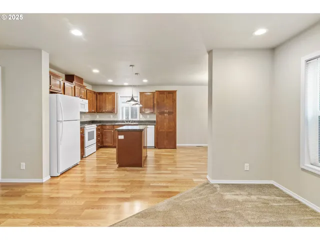 a kitchen with stainless steel appliances granite countertop a refrigerator a sink dishwasher and a oven with wooden cabinets