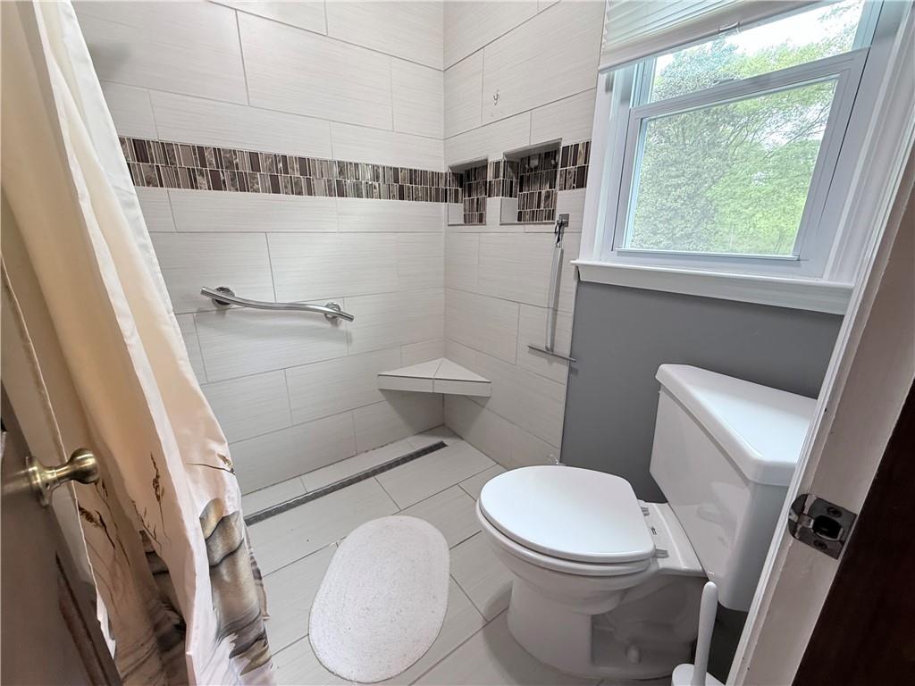 3033 Riviera Drive Conyers, GA 30012 - Photo 32 of 79 a white toilet sitting next to a bathroom sink and a shower
