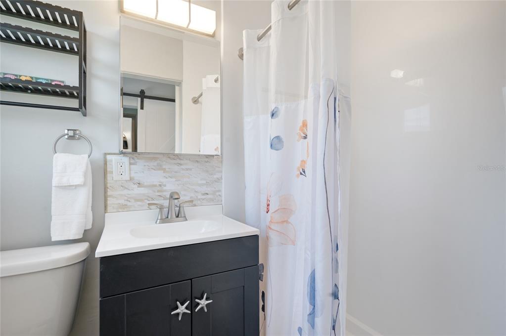 211 77th Street, Unit EAST Holmes Beach, FL 34217 - Photo 15 of 18 a bathroom with a sink and a mirror