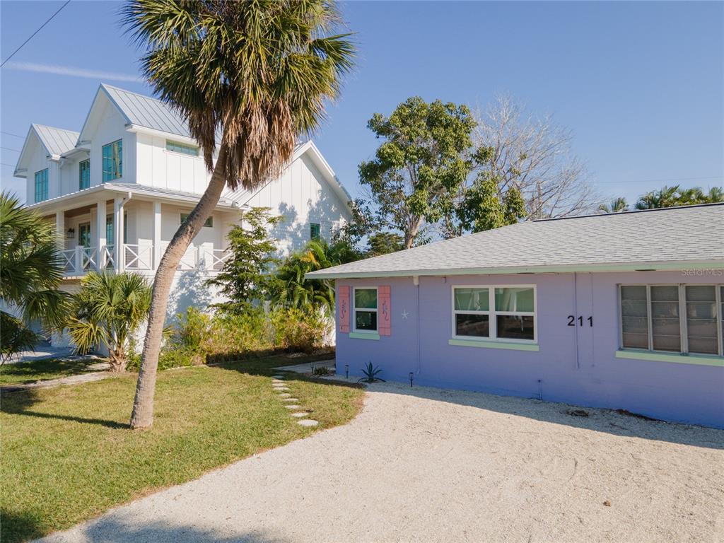 211 77th Street, Unit EAST Holmes Beach, FL 34217 - Photo 16 of 18 a view of a house with a yard