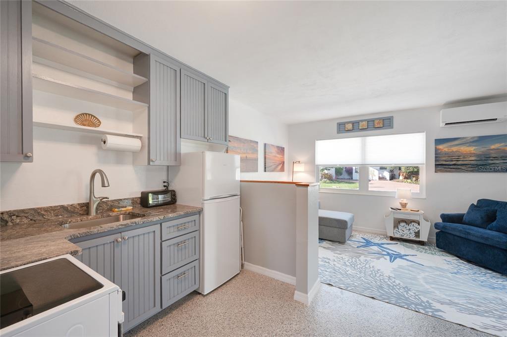 211 77th Street, Unit EAST Holmes Beach, FL 34217 - Photo 8 of 18 a kitchen with refrigerator and cabinets