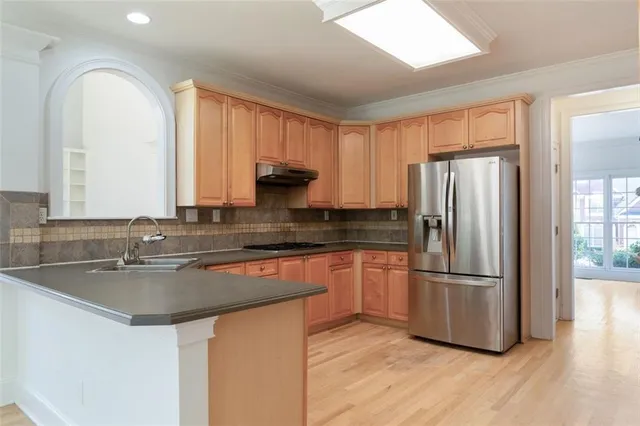 an empty room with wooden floor ceiling fan and windows