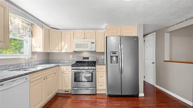 a kitchen with a stove a refrigerator and a sink