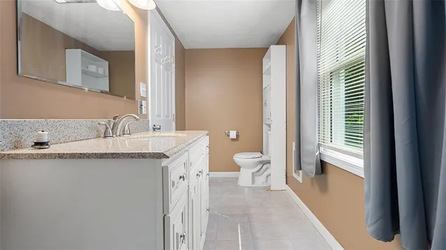 a bathroom with a granite countertop sink toilet and shower