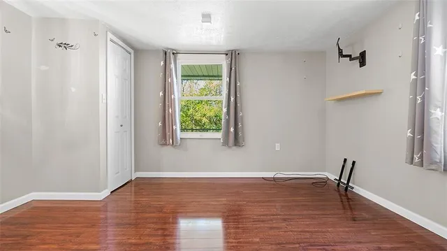 a view of room with window and wooden floor