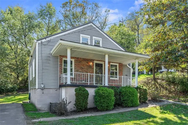 a front view of a house with a yard and potted plants