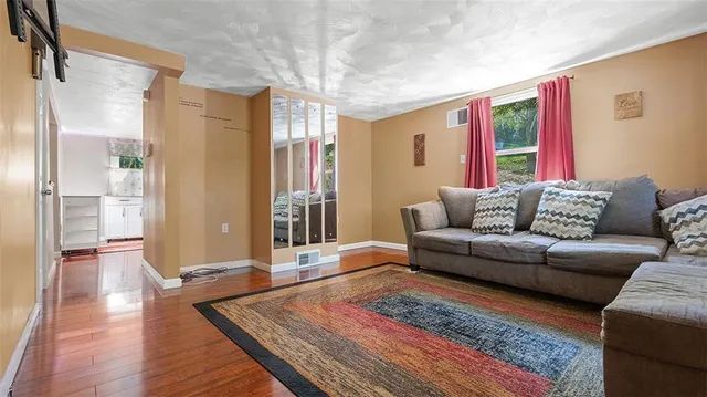 a living room with furniture and wooden floor