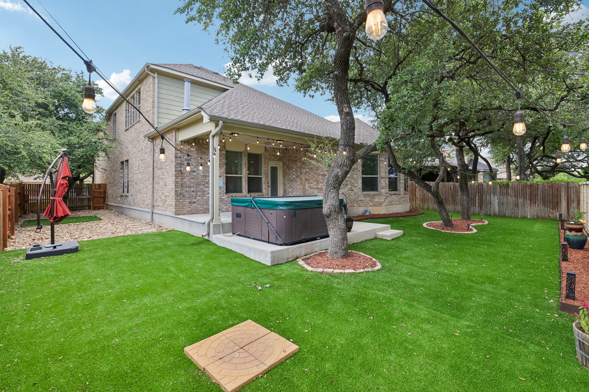 1924 Granite Springs Road Leander, TX 78641 - Photo 34 of 36 A well-maintained backyard oasis with a hot tub and string lights for evening enjoyment.