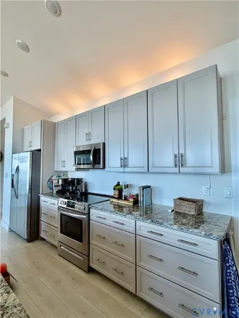 a kitchen with cabinets appliances a sink and a counter top space