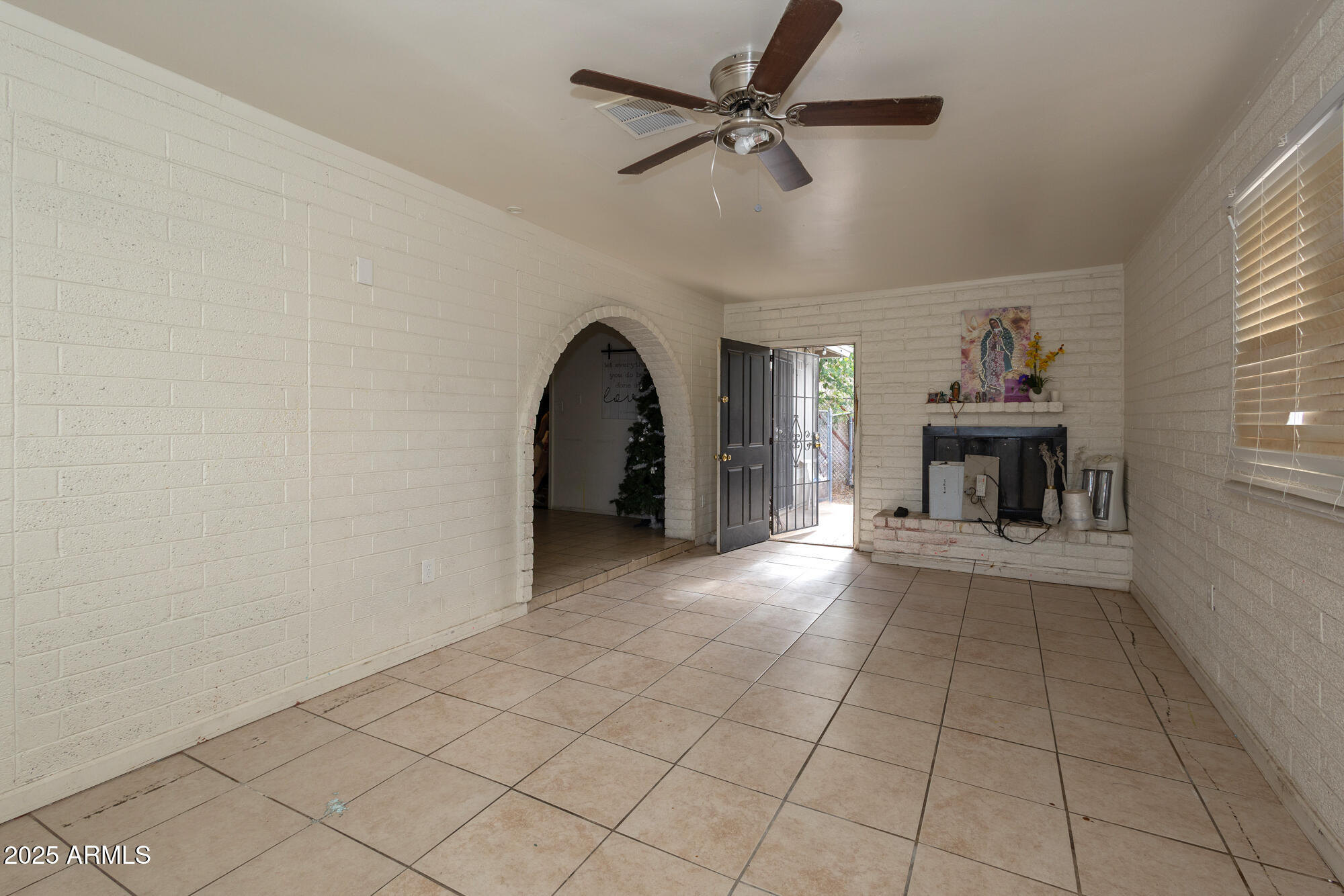 6826 South 8th Street Phoenix, AZ 85042 - Photo 8 of 22 a view of a livingroom with a fireplace a chandelier fan and windows