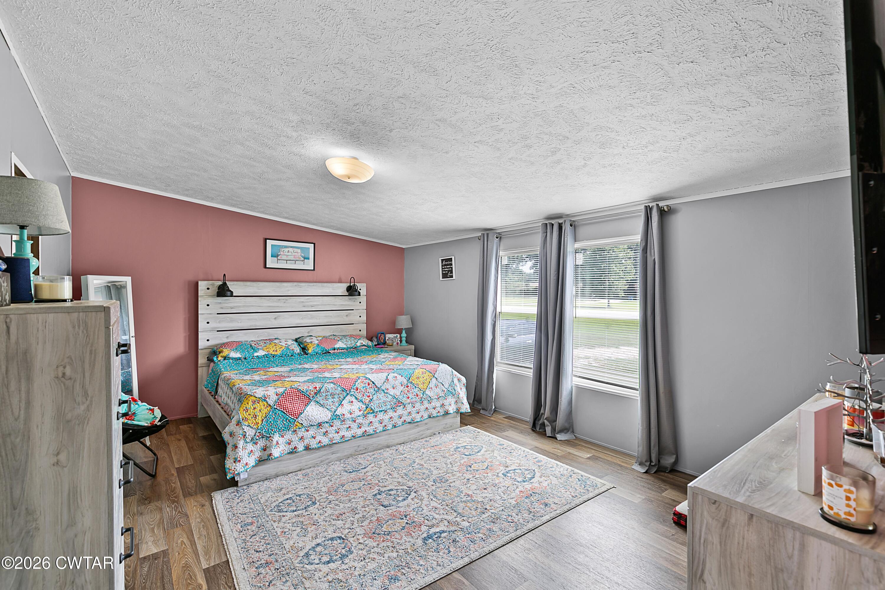 141 Persimmon Grove Road Trenton, TN 38382 - Photo 11 of 20 a bedroom with a bed and wooden floor