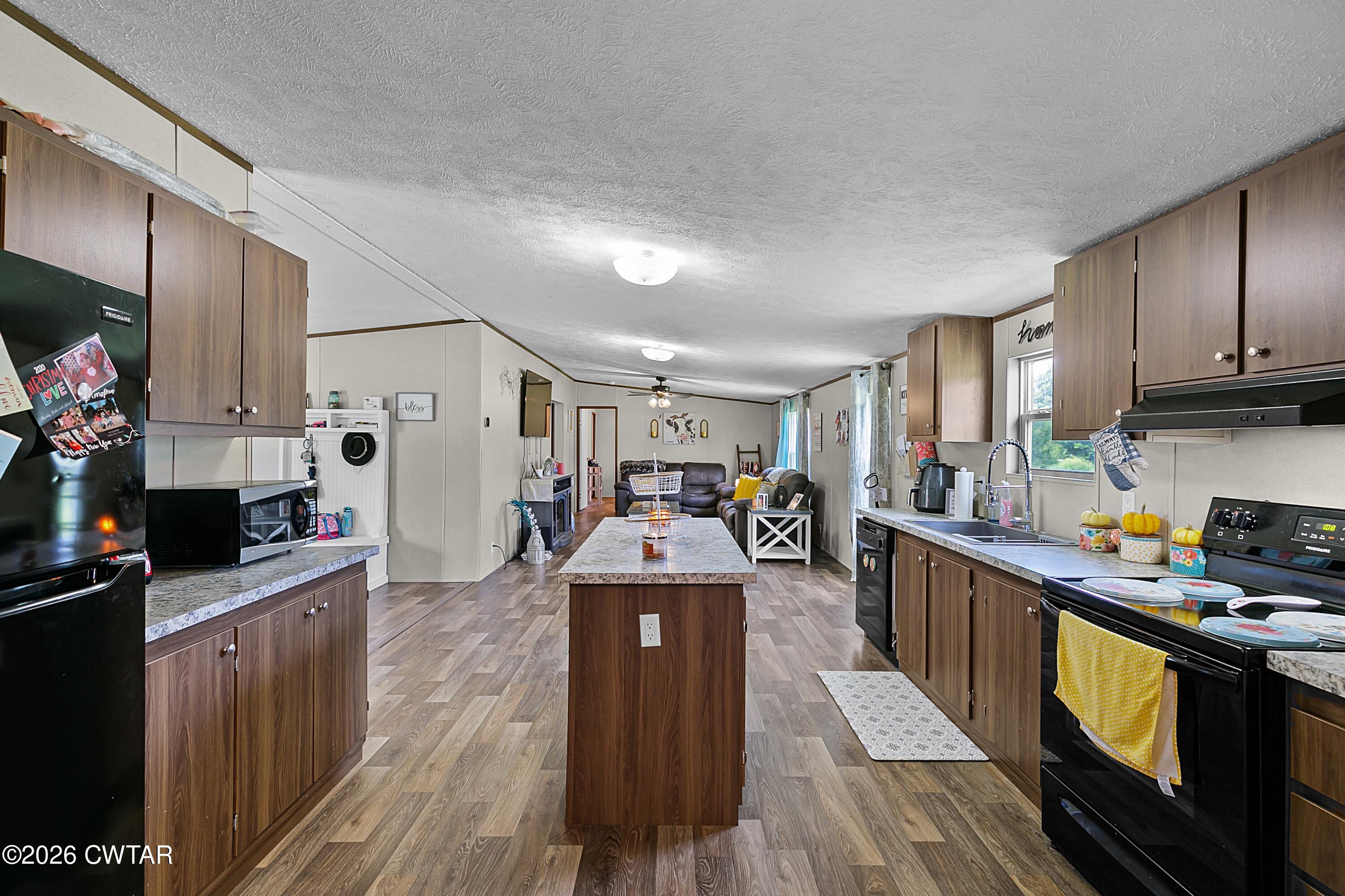 141 Persimmon Grove Road Trenton, TN 38382 - Photo 4 of 20 a kitchen with granite countertop a sink stove and cabinets