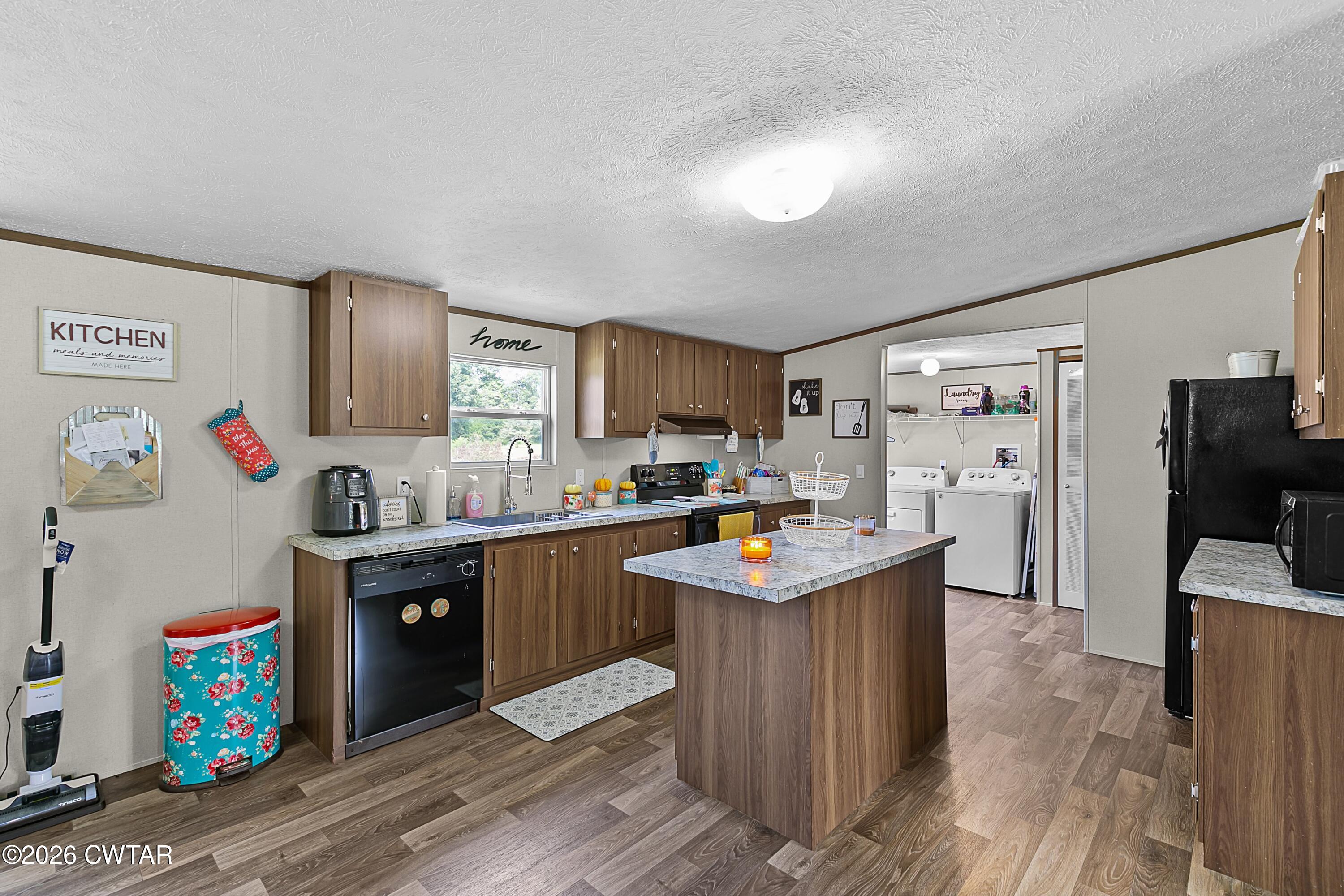141 Persimmon Grove Road Trenton, TN 38382 - Photo 5 of 20 a kitchen with stainless steel appliances kitchen island granite countertop a sink and cabinets