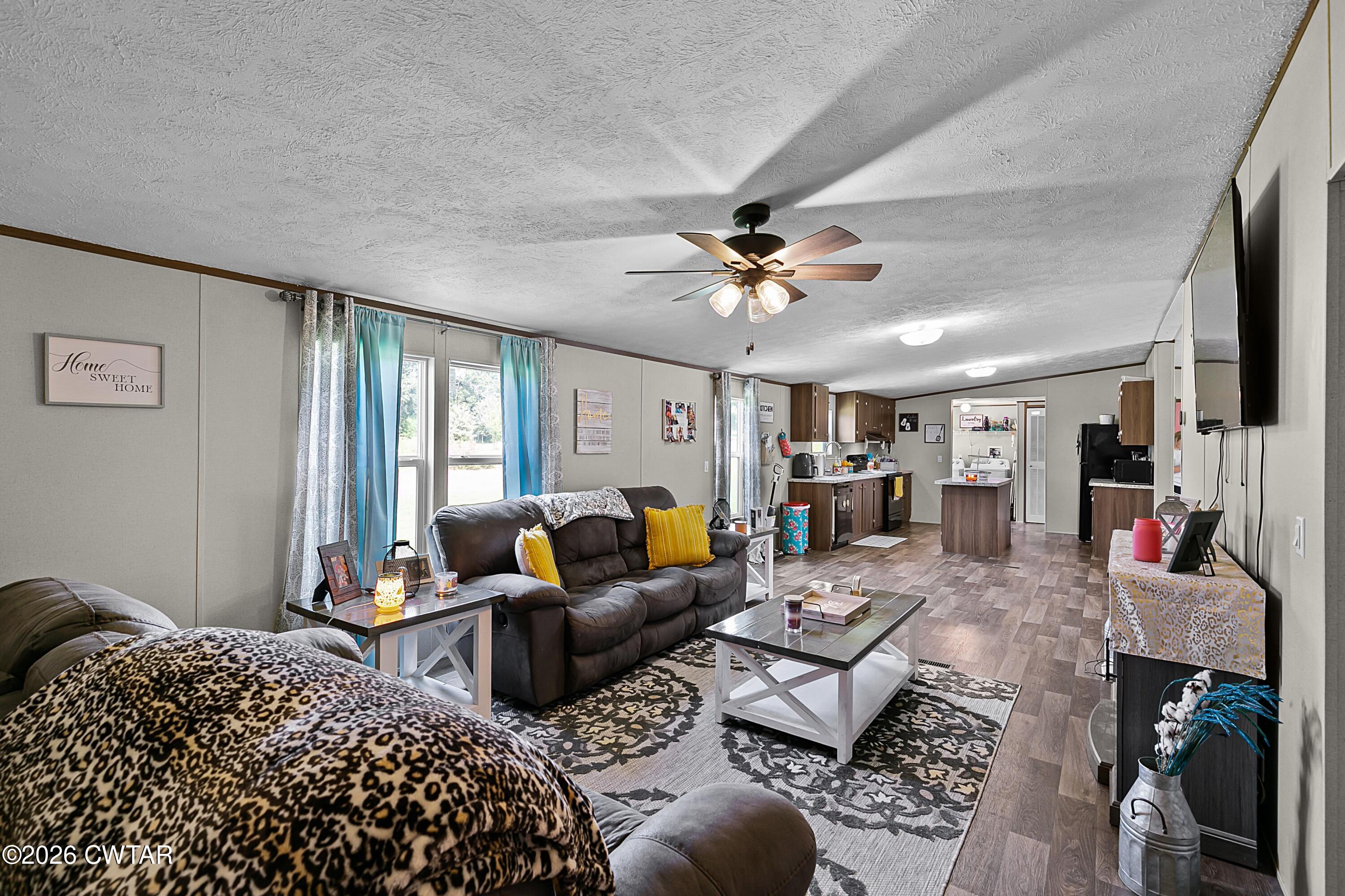 141 Persimmon Grove Road Trenton, TN 38382 - Photo 9 of 20 a living room with furniture ceiling fan and a rug
