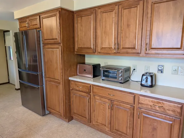 a kitchen with stainless steel appliances granite countertop a refrigerator a microwave and cabinets