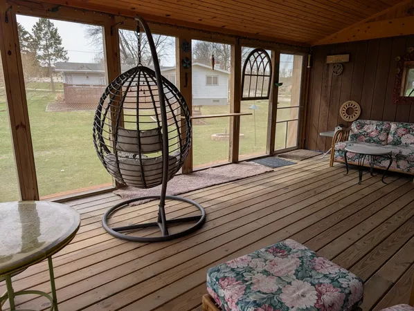 a living room with furniture a rug wooden floor and a large window