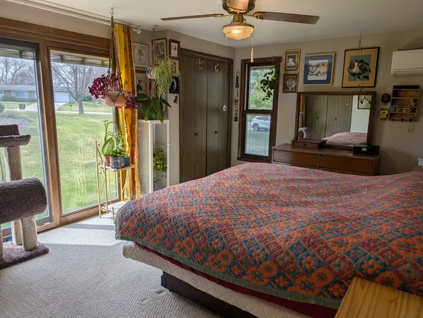 a bedroom with a bed mirror and a large window