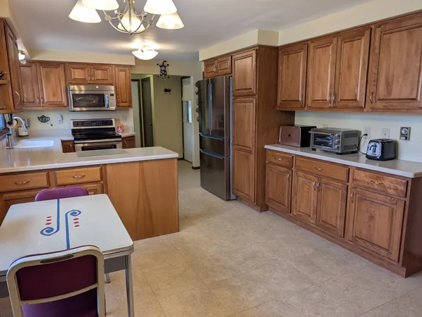 a kitchen with stainless steel appliances a refrigerator and a stove top oven
