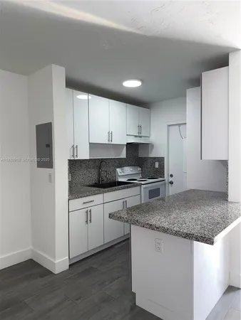 a kitchen with granite countertop a sink and a stove top oven