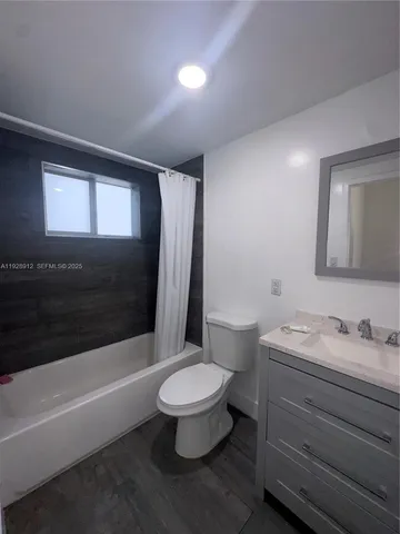 a bathroom with a sink a toilet a mirror and bathtub
