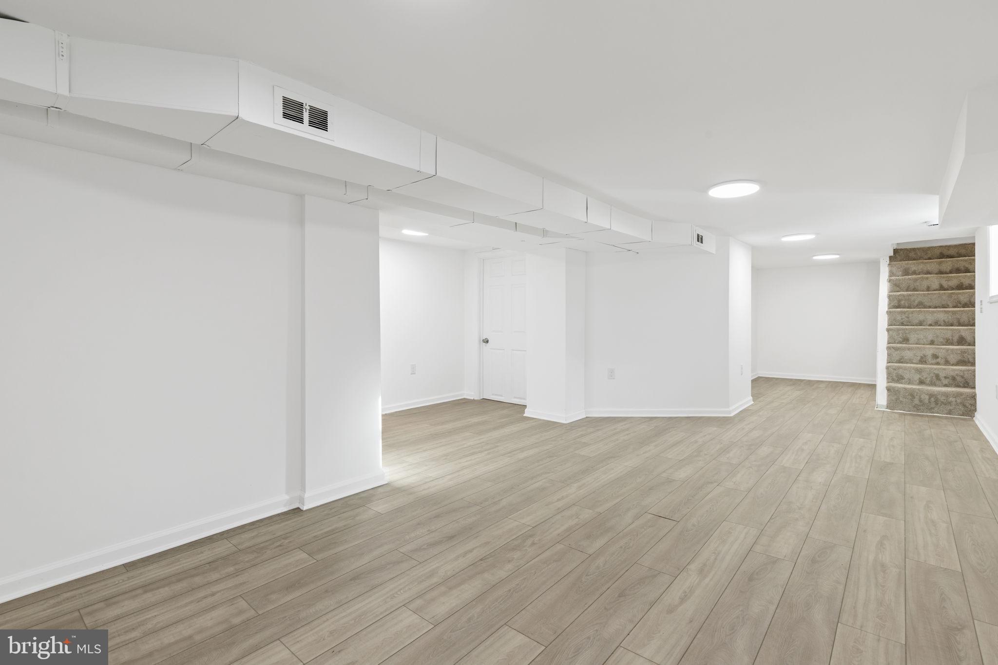 5613 Plymouth Road Baltimore, MD 21214 - Photo 15 of 31 a view of an empty room with wooden floor