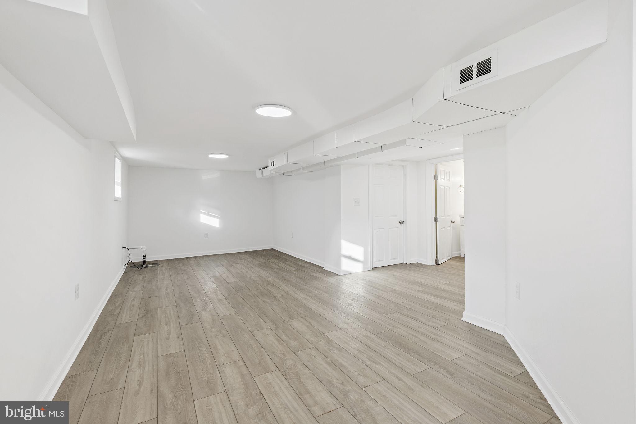 5613 Plymouth Road Baltimore, MD 21214 - Photo 16 of 31 a view of an empty room with wooden floor