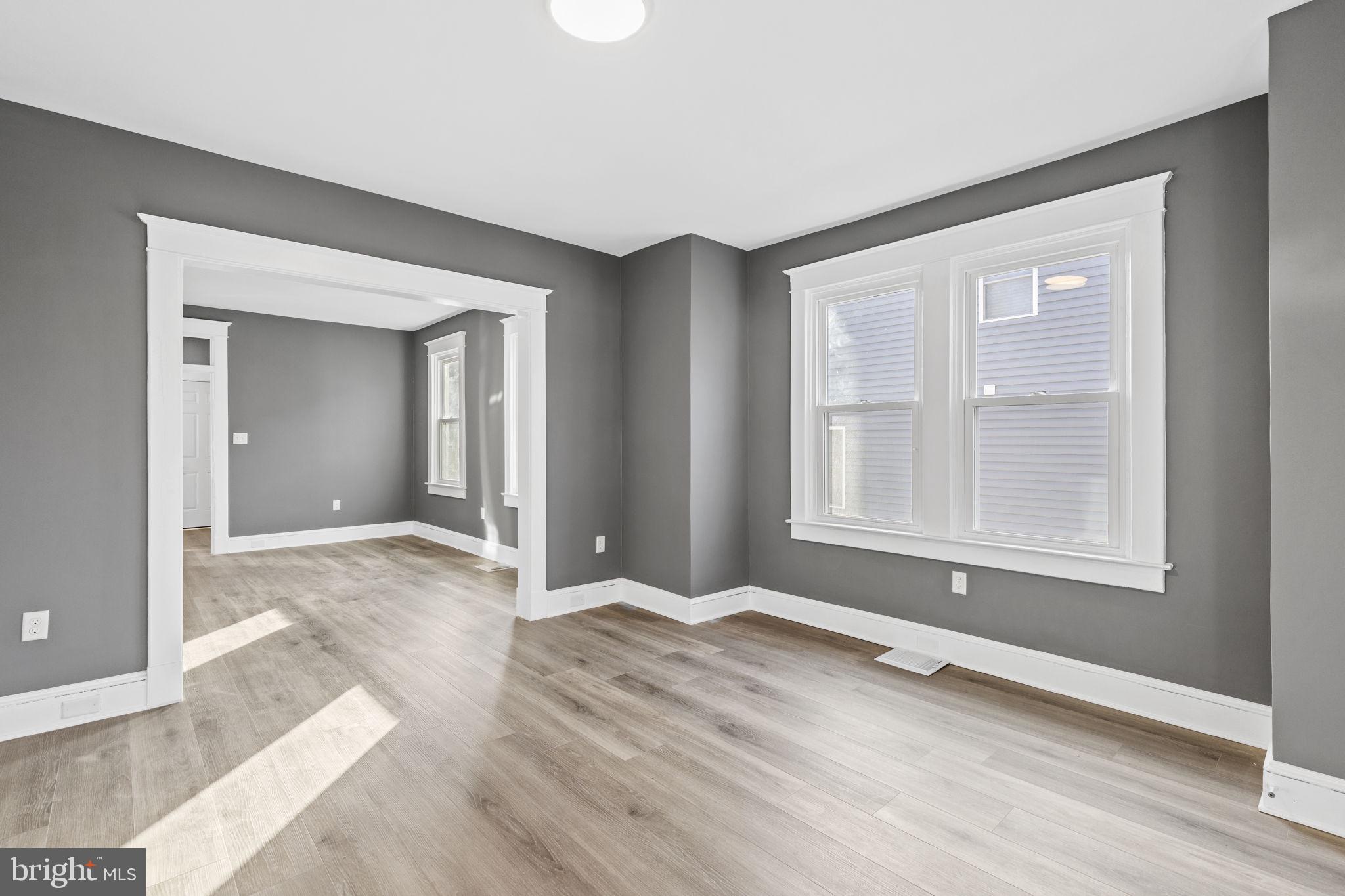 5613 Plymouth Road Baltimore, MD 21214 - Photo 3 of 31 an empty room with wooden floor and windows