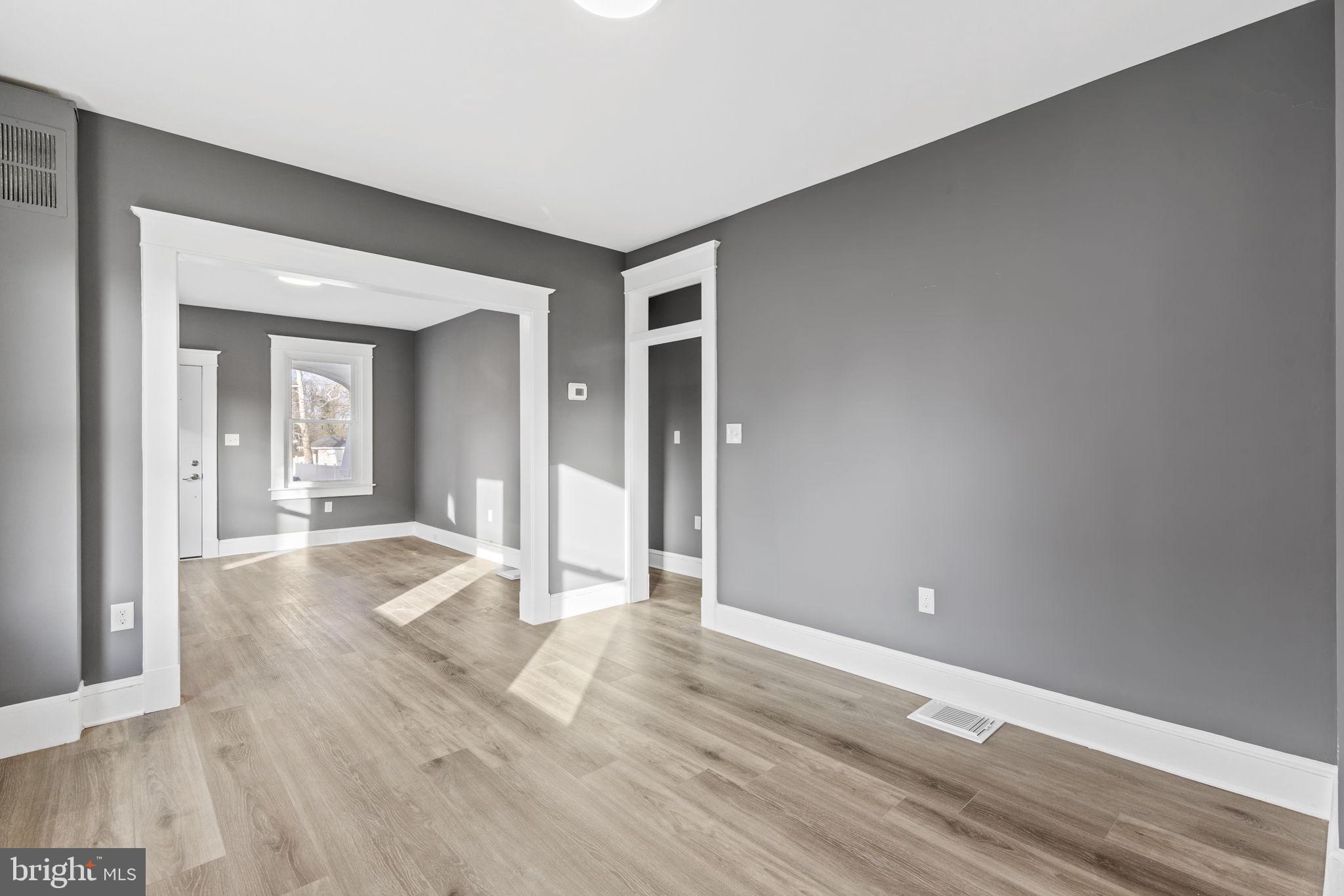 5613 Plymouth Road Baltimore, MD 21214 - Photo 5 of 31 an empty room with wooden floor and mirror