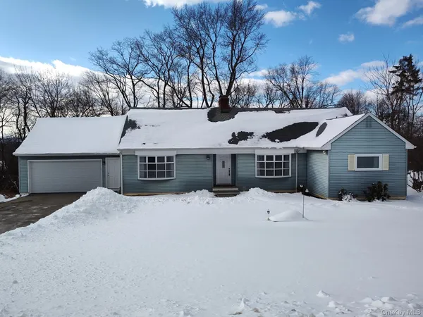 a front view of a house with a yard covered in snow