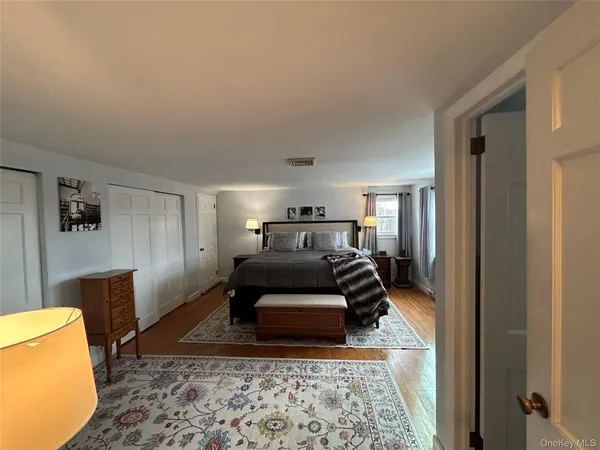 a view of a hallway with wooden floor and cabinet