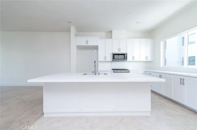 a kitchen with kitchen island sink stove and refrigerator