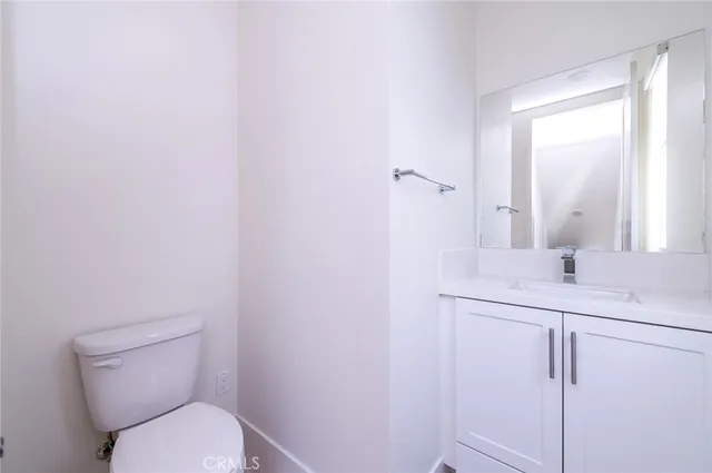 a bathroom with a toilet sink vanity and mirror