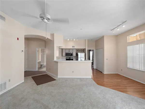 a large white kitchen with kitchen island a sink stainless steel appliances and cabinets