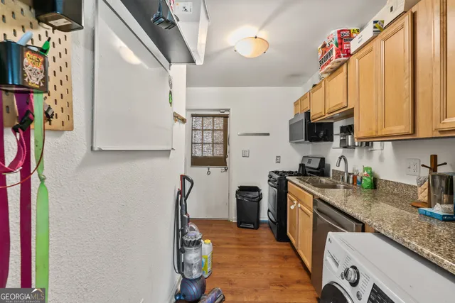 a kitchen with stainless steel appliances granite countertop a refrigerator a stove top oven a sink and dishwasher