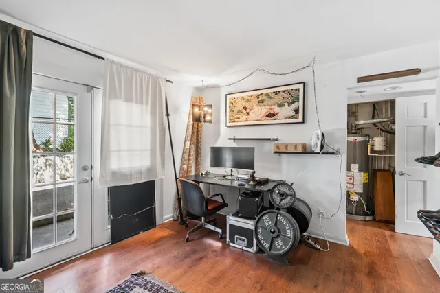 a view of a workspace with furniture and a window