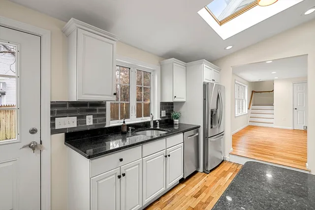 a kitchen with granite countertop white cabinets and white appliances