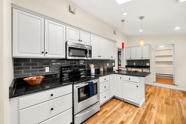 a kitchen with stainless steel appliances a stove sink microwave and cabinets