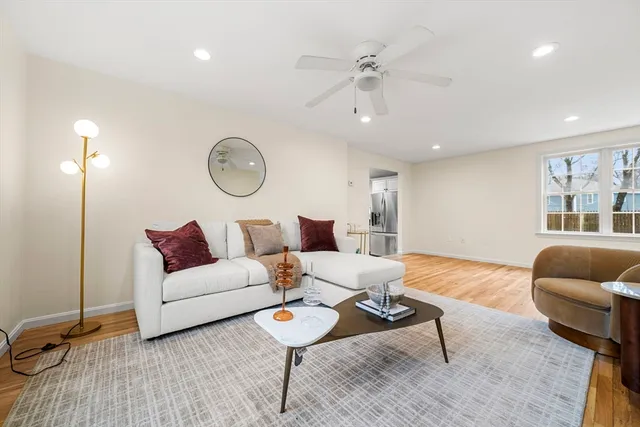 a view of an empty room with wooden floor and stairs