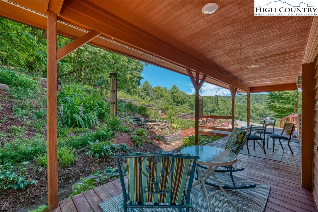 363 Misty Mountain Road Boone, NC 28607 - Photo 15 of 50 a balcony with wooden floor table and chairs